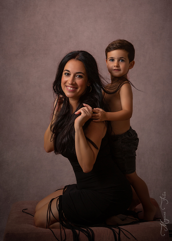 Fotografía madre e hijo abrazandola en fondo rosa