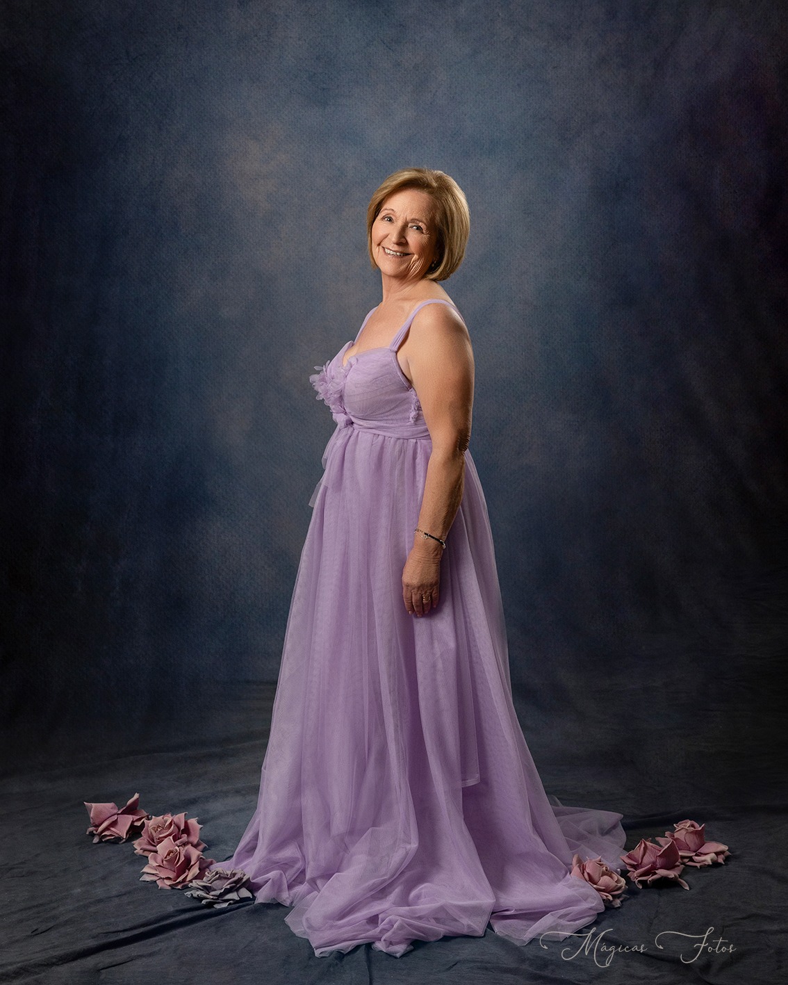 Fotografía de una mujer con vestido morado mirando sonriendo a la cámara